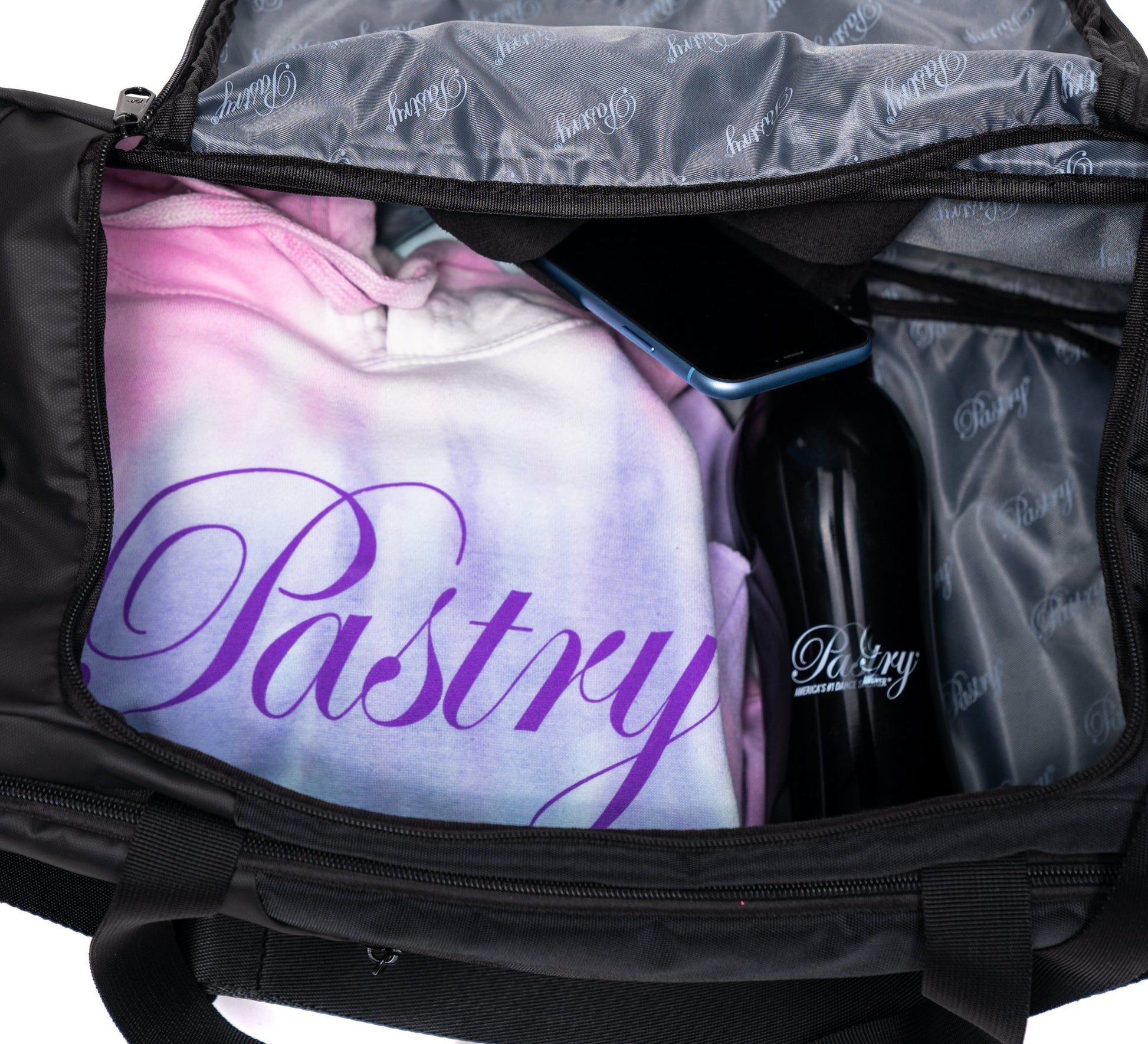 Pastry Duffle Bag Solid Black with clothes and tumbler inside